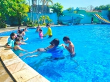 Các em học sinh được các giáo viên dạy bơi hướng dẫn các động tác bơi cơ bản