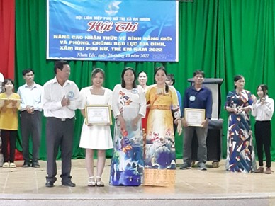 Chị Lê Vũ Vân Kiều-CT Hội LHPN thị xã (áo dài vàng) trao giải cho gia đình đạt giải nhất ở xã Nhơn Lộc
